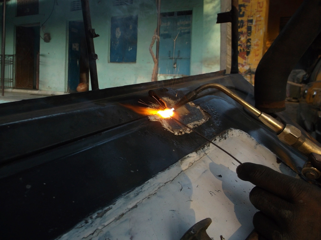 Welder joining steel sheet in a metal workshop